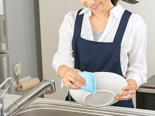 皿を洗っている女性スタッフ